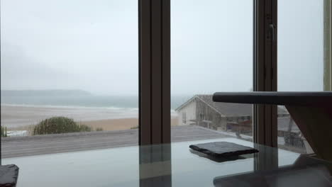 Raindrops-Falling-against-Glass-Doors-with-a-Coffee-Table-in-Foreground