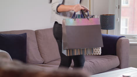 Young-Woman-Sits-On-Sofa-After-Successful-Shopping-Trip,-In-Slow-Motion