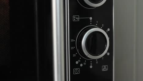 Setting-microwave-timer-to-ten-minutes-and-turning-microwave-off---close-angled-shot