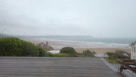 Static-Shot-of-Raindrops-Falling-Down-a-Window-with-an-Ocean-View