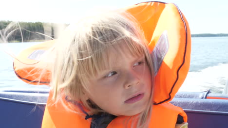 Kind-Auf-Boot-Mit-Rettungsring-Und-Haaren-Im-Wind