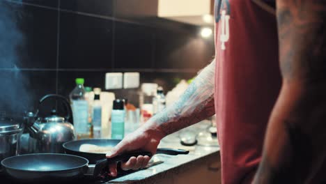 Hombre-Musculoso-Con-Tatuajes-Volteando-Filete-De-Atún-En-Una-Sartén-Mientras-Cocina-La-Cena-Keto