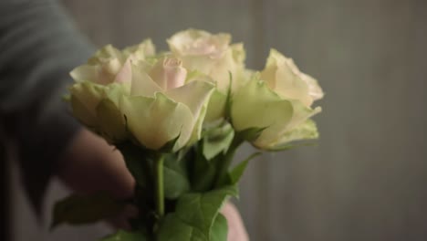 Hand-placing-bunch-of-pink-and-white-pastel-roses-in-a-vase