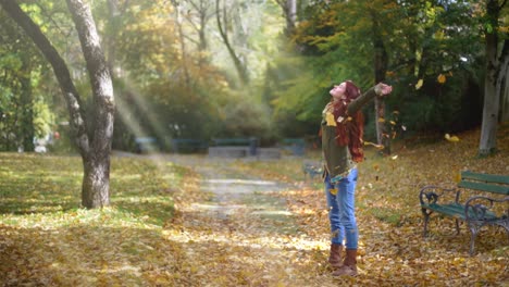 Slow-Motion:-Beautiful-young-redhead-woman-standing-in-a-park-in-autumn-with-leaves-falling-down-around-her-1