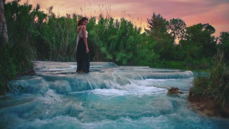 4K-UHD-Cinemagraph---seamless-video-loop-of-a-young-woman-standing-in-a-thermal-hot-springs-waterfall-in-Saturnia,-Italy