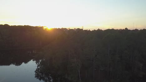 Aerial-Shot-Ascending-Over-Lake-into-Sunset-With-Lens-Flare
