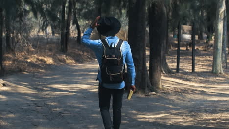 Guy-walking-in-the-woods-with-a-book-in-its-hand