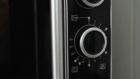 Setting-microwave-timer-to-two-minutes-and-turning-microwave-off---close-angled-shot