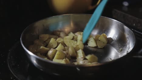 Moving-The-Skillet-And-Turning-The-Slices-Of-Potatoes-Using-a-Spatula---Close-Up-Shot