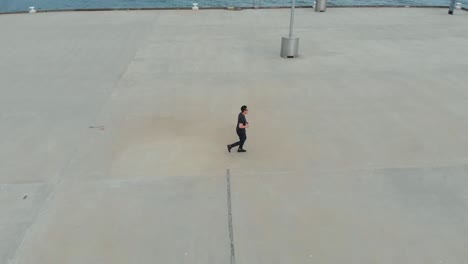 Drone-Filming-Asian-Male-Running-On-Princess-Pier-In-Port-Melbourne