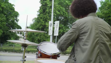 Junger-Afro-Schlagzeuger-Draußen.-Möglicherweise-Ein-Straßenkünstler