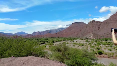 A-woman-with-a-camera-takes-photographs-of-the-beautiful-landscape-of-the-Quebrada-de-Cafayate-region-in-Argentina