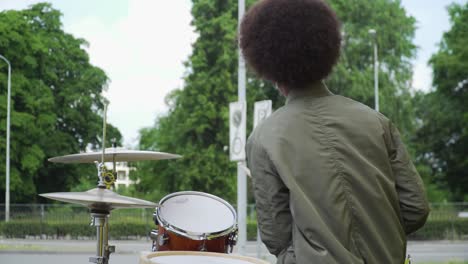 Junger-Afro-teenager,-Der-Draußen-Laute-Trommeln-Spielt