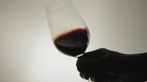 Swirling-The-Glass-Of-Wine-In-A-Leaning-Position---Close-Up-Shot