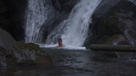 A-Man-Enjoying-The-Natural-Waterfall-Spa-Massage---Medium-Shot