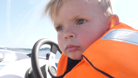Close-up-of-child-driving-a-boat-to-play