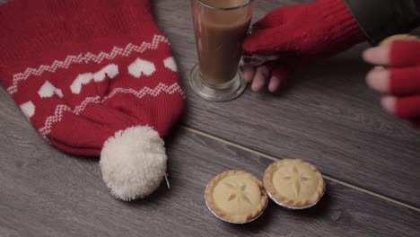 Hand-wearing-winter-gloves-grabbing-pies-and-coffee