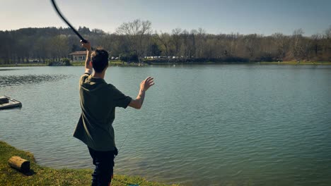 Slow-motion-view-of-man-using-a-tool-to-throw-bait-into-the-water-to-attract-carp