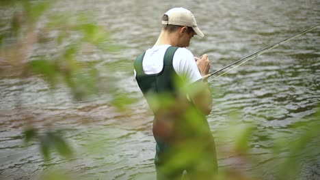 Slow-Motion-Shot-of-a-Caucasian-male-fisherman-preparing-his-hook-while-Fly-Fishing-1