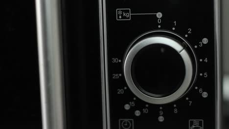 Setting-microwave-timer-to-two-minutes-and-turning-microwave-off---close-up-shot---front-view