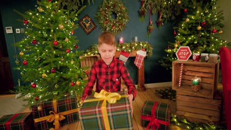 Young-box-holds-up-his-Christmas-present-while-spinning-it-in-between-his-hands