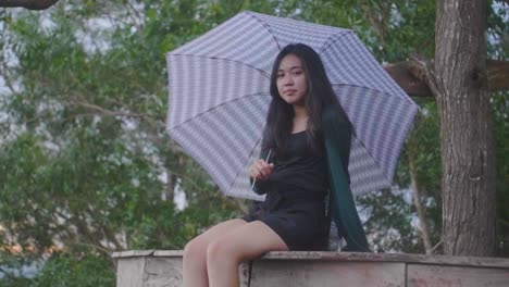 Slow-motion-footage-of-girl-sitting-on-deck-holding-an-umbrella