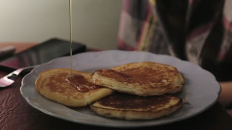Spreading-Slowly-The-Maple-Syrup-On-Pancakes---Close-Up-Shot