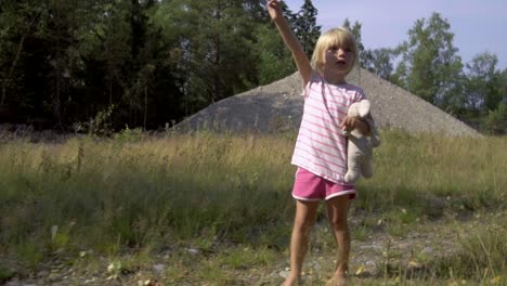 Cute-three-year-old-girl-on-adventure,-walking-barefoot-in-lovely-summer-weather,-gimbal-4K