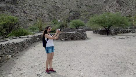 A-young,-attractive-woman-shooting-video-of-the-Quilmes-Ruins-in-Argentina