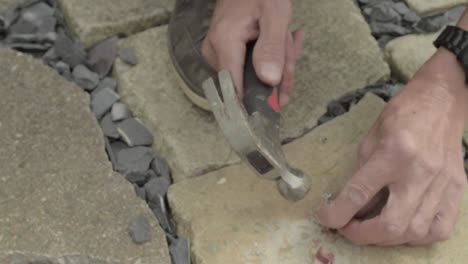 Workman-hands-hammering-nails-into-nail-hook-cable-clip-on-concrete-floor-1