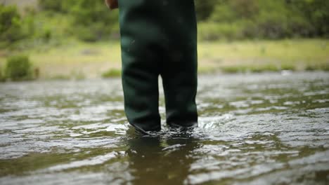 Slow-Motion-Shot-of-a-Caucasian-male-fisherman-preparing-his-hook-while-Fly-Fishing