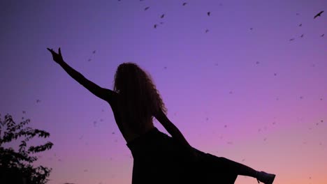 A-Beautiful-Woman-Dancing-To-The-Tune-Of-Nature-And-Reaching-For-The-Purple-Sky---Low-Angle-Shot