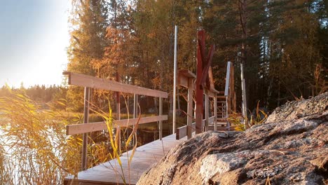 Touristenjunge-Auf-Wanderweg-Im-Nationalpark-In-Finnland,-Allein-Zu-Fuß-über-Holzbrücke,-Wunderschöne-Seenaturlandschaft