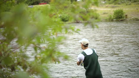 Slow-Motion-Shot-of-a-Caucasian-male-fisherman-casting-his-hook-while-Fly-Fishing-6