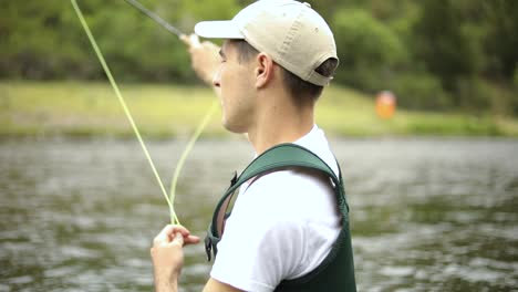 Slow-Motion-Shot-of-a-Caucasian-male-fisherman-casting-his-hook-while-Fly-Fishing-10
