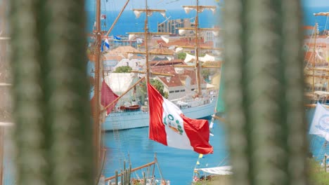 Schiff,-Das-Die-Farben-Von-Peru-Und-Portugal-Trägt,-Während-Die-Flaggen-Im-Wind-Wehen,-Während-Das-Schiff-Im-Hafen-Anlegt