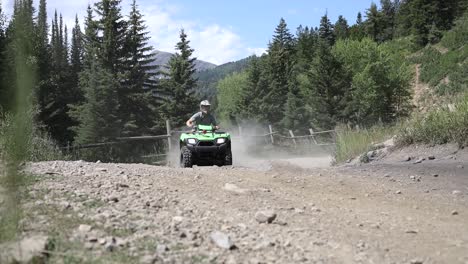 Shot-of-an-ATV-Rider-driving-his-quad-really-fast-around-a-corner,-leaving-a-large-dirt-cloud-behind-him