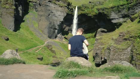 Man-playing-guitar-in-front-of-a-beautiful-waterfall-in-Iceland-22