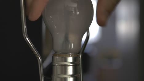 Hand-Removing-Lightbulb-From-The-Socket---closeup-shot