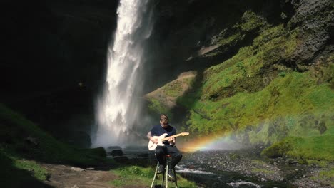Man-playing-guitar-in-front-of-a-beautiful-waterfall-in-Iceland-23