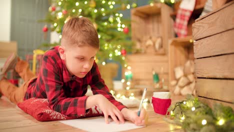 Young-boy-lays-on-the-floor-and-thinking-about-his-Christmas-wish-list