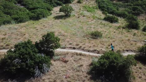 Drone-Shot-following-an-active-man-running-on-the-outdoor-Wasatch-Mountain-trails-above-Draper-City,-Utah-2