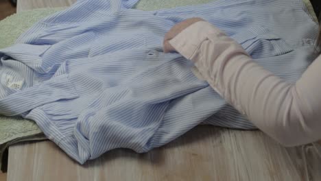 Woman-folding-shirt-after-doing-the-laundry