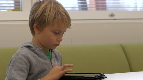 Junge-Nordische-Grundschülerin-Surft-Tablet,-Zeitlupe