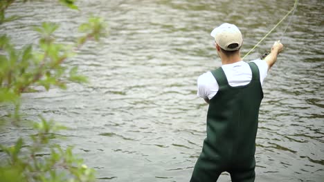 Slow-Motion-Shot-of-a-Caucasian-male-fisherman-casting-his-hook-while-Fly-Fishing-8