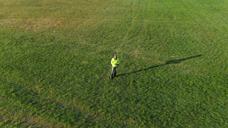 Aerial-drone-shot-circling-around-man-standing-in-the-field