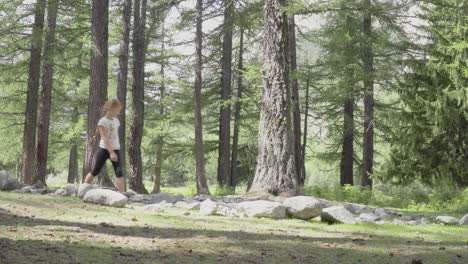 Little-girls-walks-through-rocks-in-a-forest,-4K