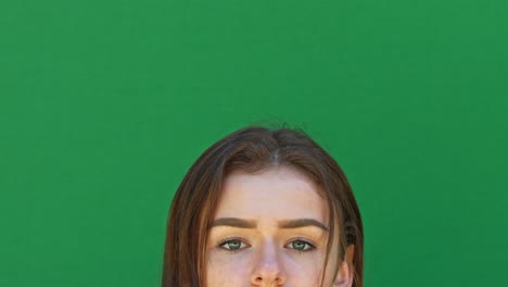 Happy-brunette-adult-girl-looking-up-to-empty-green-copy-space