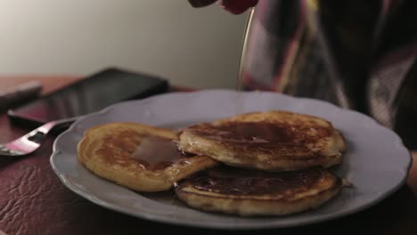 Pouring-And-Adding-More-Maple-Syrup-On-A-Plate-Of-Pancakes---Close-Up-Shot