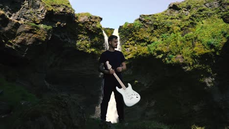 Mann-Spielt-Gitarre-Vor-Einem-Wunderschönen-Wasserfall-In-Island-24